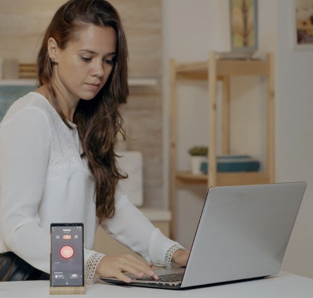 Remote employee using a laptop and digital devices while working from home.